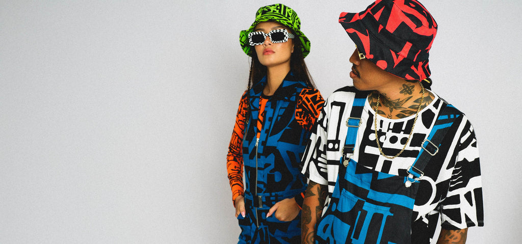 People dressed in Bam-Bam apparel, hats, jumpsuit, t-shirt are colorful and designed with cubist abstract patterns.