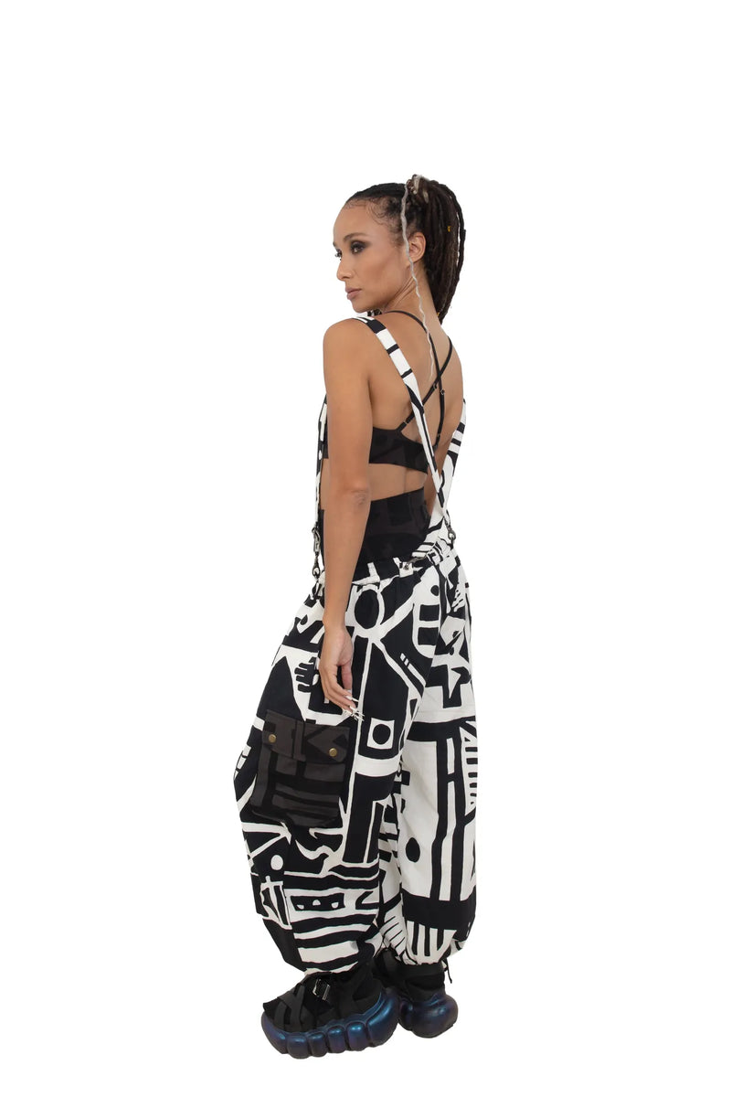 Model wearing BAM-BAM black and white abstract print overalls, side view with strappy back design.