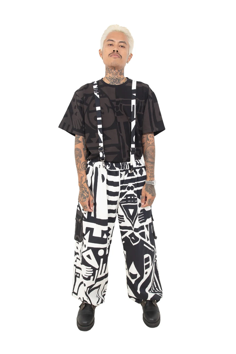 Male model in BAM-BAM black and white overalls with bold graphic print and black t-shirt, front view.