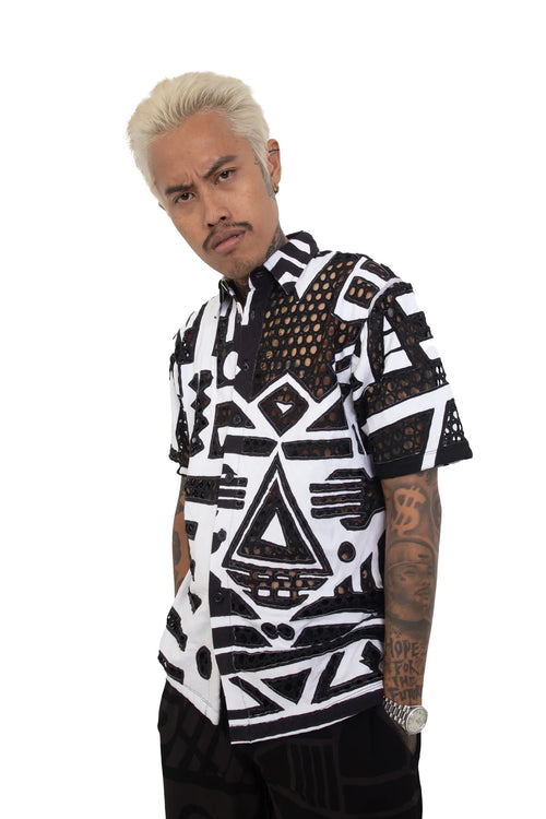 Male model wearing black and white BAM‑BAM mesh shirt with circular cutouts showcasing cubist patternism