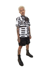 Side view of model in BAM‑BAM round mesh shirt and black trousers demonstrating abstract prints