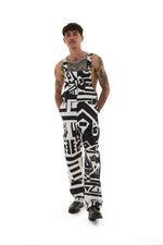 Male model with tattoos wearing black and white BAM‑BAM dungarees featuring cubist patternism and self‑expression