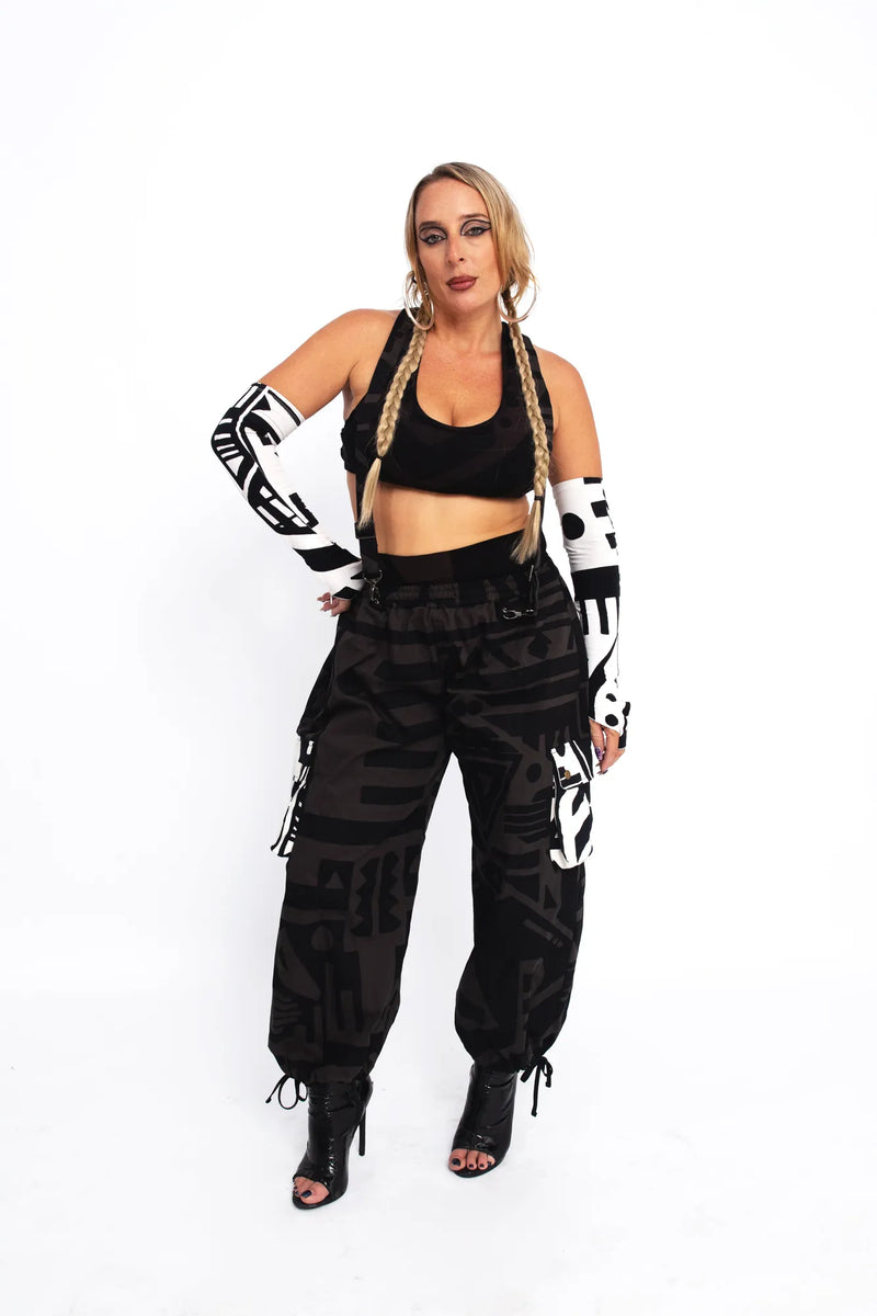 Model standing with hands on hips in charcoal BAM‑BAM baggy pants capturing wearable art
