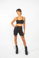 Model posing with hands on hips in charcoal black BAM‑BAM bra top demonstrating self‑expression