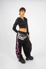 Model with hands in pockets wearing charcoal and pink BAM‑BAM poppa pants demonstrating self‑expression