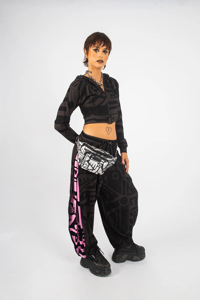 Model with hands in pockets wearing charcoal and pink BAM‑BAM poppa pants demonstrating self‑expression