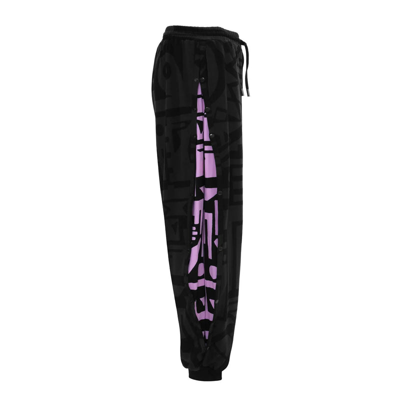 Model flipping hair in charcoal and pink BAM‑BAM poppa pants capturing bold self‑expression