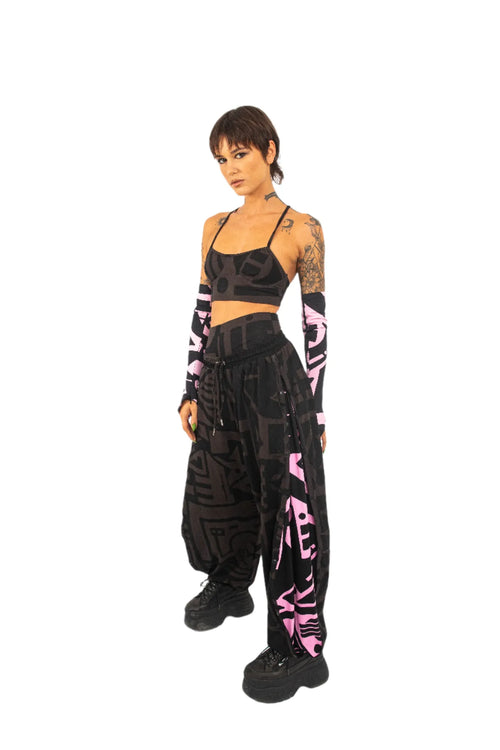 Model wearing charcoal and pink BAM‑BAM poppa pants with matching bra top, showcasing wearable art