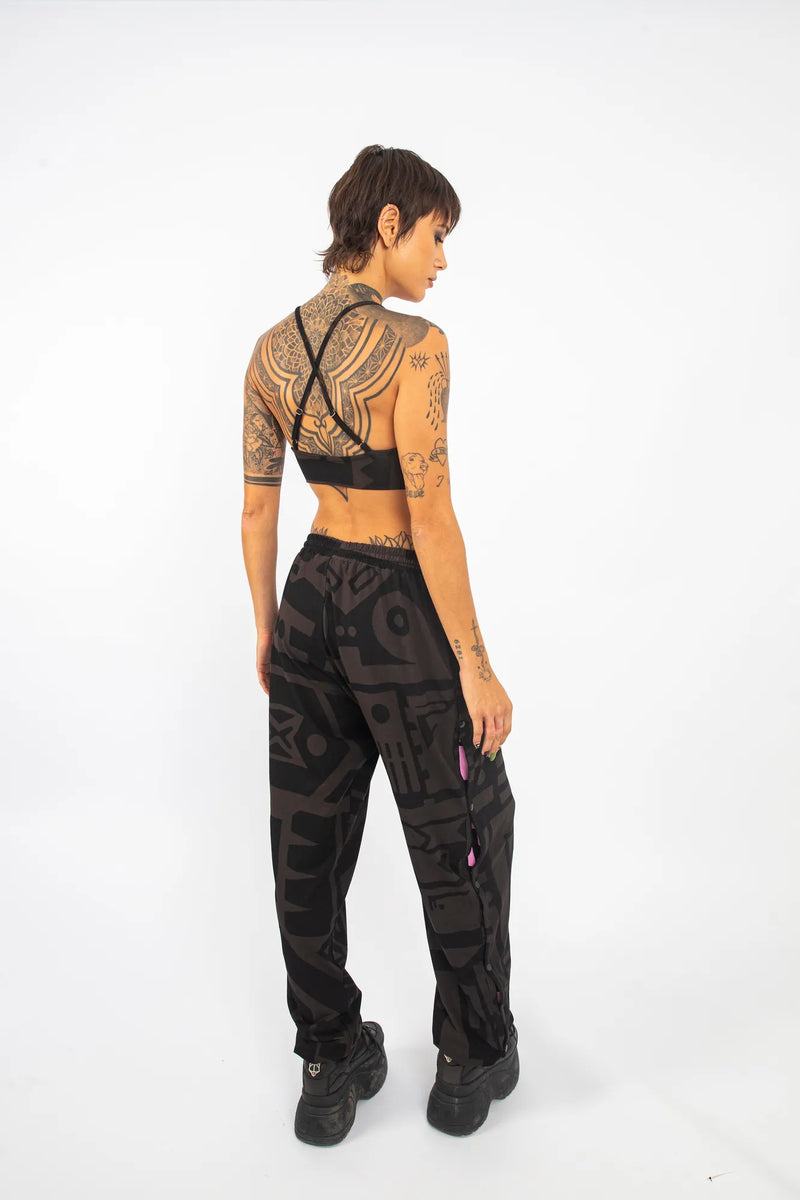 Close‑up of BAM‑BAM poppa pants buttons and pink stripe highlighting design details