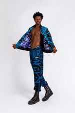 Model stretching in dark blue BAM‑BAM trousers and bra top with abstract prints