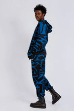 Model wearing dark blue and black BAM‑BAM trousers with abstract prints and cubist patternism