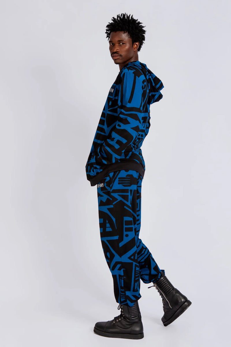 Model wearing dark blue and black BAM‑BAM trousers with abstract prints and cubist patternism