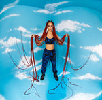 Model on blue background in BAM‑BAM dark blue bra top and trousers reflecting self‑expression