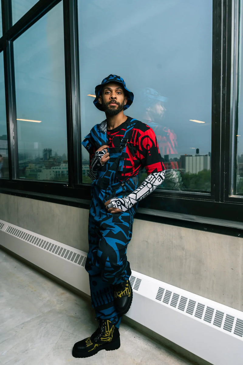 Side view of dark blue and black BAM‑BAM dungarees worn by model, showcasing artistic streetwear