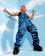 Wide shot of model in BAM‑BAM dark blue dungarees with bucket hat, streetwear meets wearable art