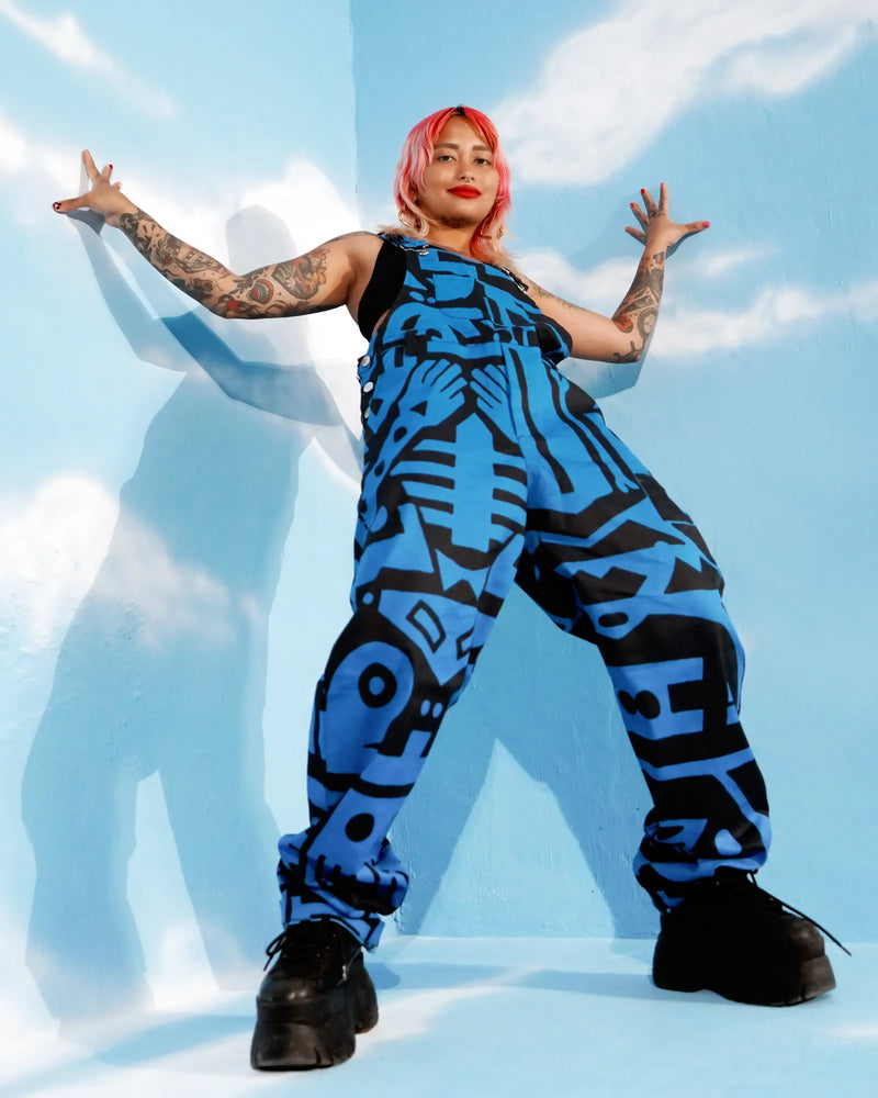 Wide shot of model in BAM‑BAM dark blue dungarees with bucket hat, streetwear meets wearable art