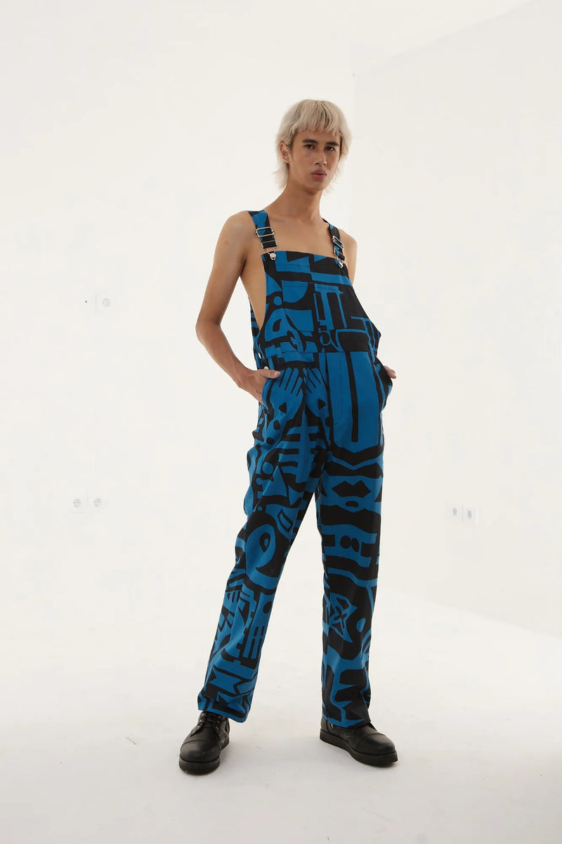 Model sitting showing front view of BAM‑BAM dark blue dungarees with artistic streetwear design