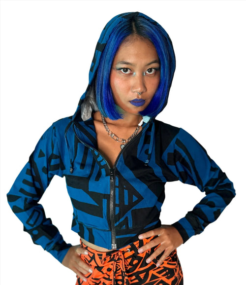Model with blue hair wearing dark blue BAM‑BAM mini hoodie and trousers, showcasing artistic streetwear