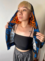 Model zipped up dark blue BAM‑BAM hoodie revealing inner orange lining, wearable art