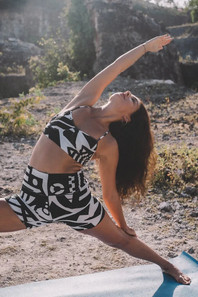 Model practicing yoga outdoors in BAM‑BAM black and white bra top and matching shorts highlighting sustainable streetwear